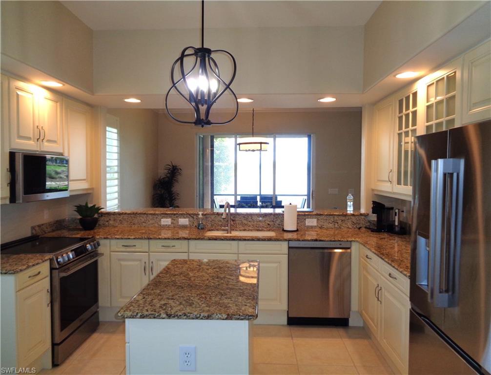 734 Regency Reserve Circle, Unit 2701 Naples, FL 34119 - Photo 8 of 37 a kitchen with stainless steel appliances granite countertop a sink stove and refrigerator