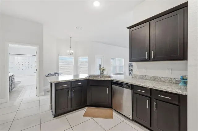 a kitchen with a sink a stove top oven and wooden cabinetry