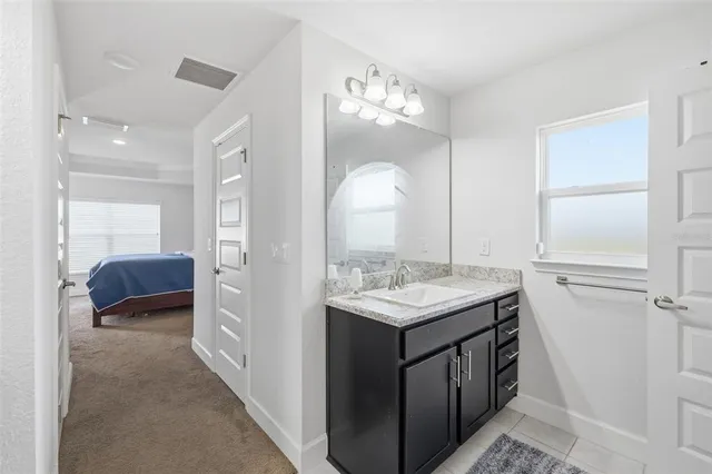a en suite bathroom with a sink a vanity and a mirror