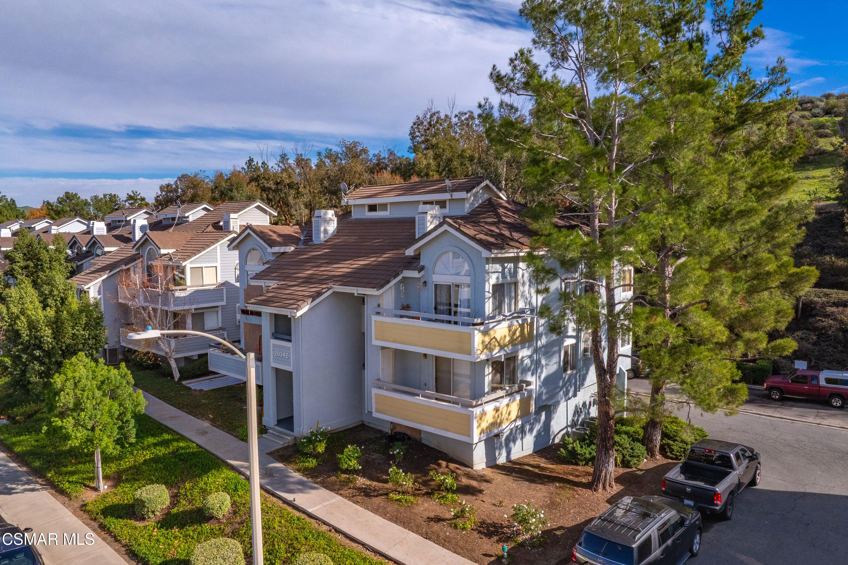 20342 Rue Crevier, Unit 613 Canyon Country, CA 91351 - Photo 26 of 36 a view of a large building with a tree in the background
