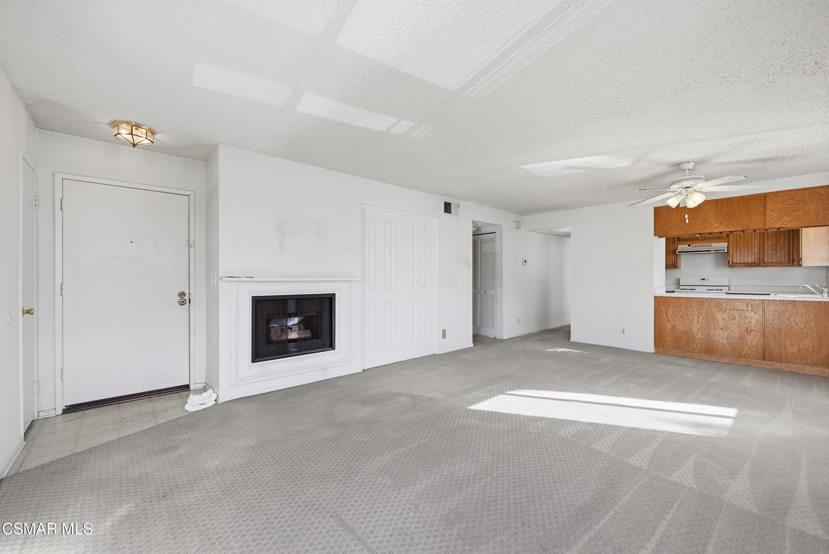 20342 Rue Crevier, Unit 613 Canyon Country, CA 91351 - Photo 8 of 36 a view of an empty room with a fireplace and a window