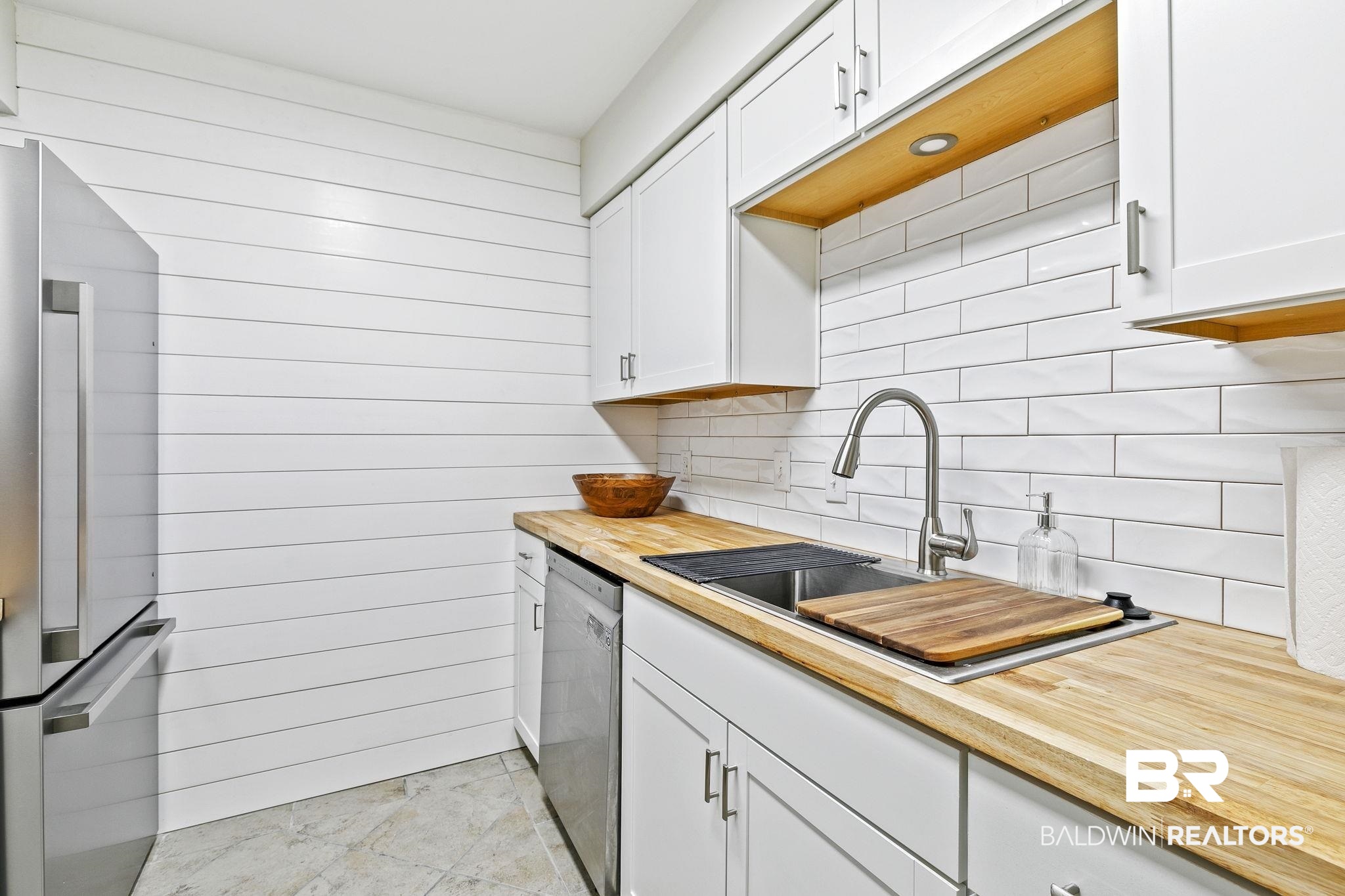 110 5th Street, Unit C103 Daphne, AL 36526 - Photo 19 of 46 Kitchen featuring tasteful backsplash, appliances with stainless steel finishes, sink, and white cabinetry