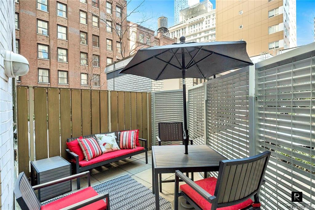 a roof deck with a table and chairs under an umbrella