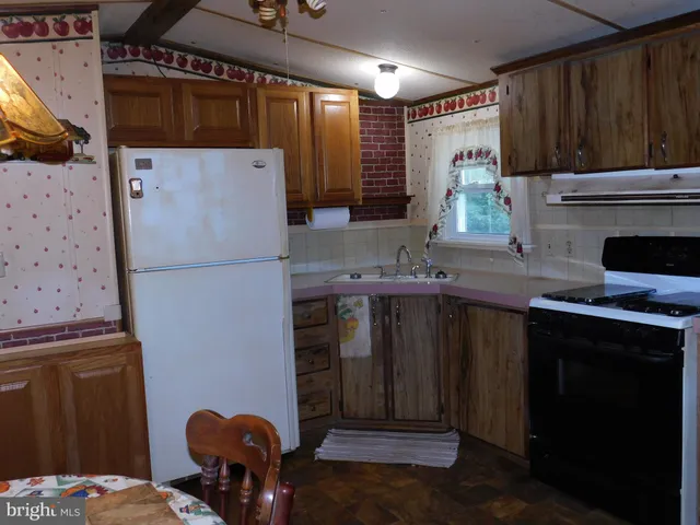 a kitchen with a refrigerator and a stove top oven
