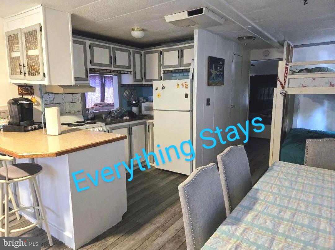 111 Beach Harbor Road Grasonville, MD 21638 - Photo 5 of 15 a kitchen with stainless steel appliances granite countertop a refrigerator a stove a sink dishwasher and wooden cabinets