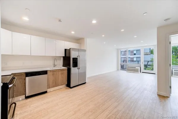 a kitchen with stainless steel appliances a refrigerator and wooden floor