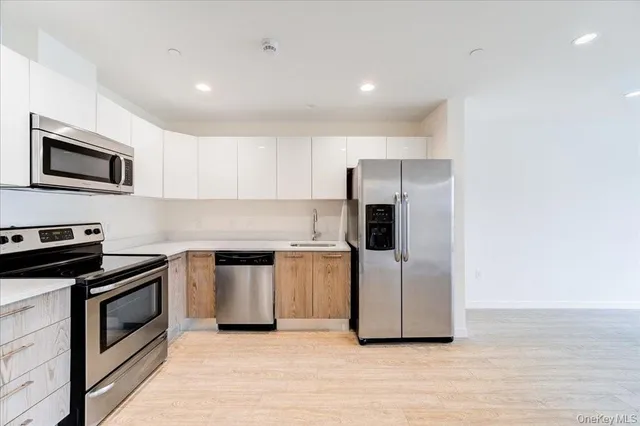 a kitchen with a sink and steel appliances