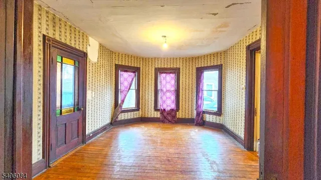a view of an entryway door with hallway and wooden floor