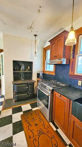a kitchen with granite countertop a stove and cabinets