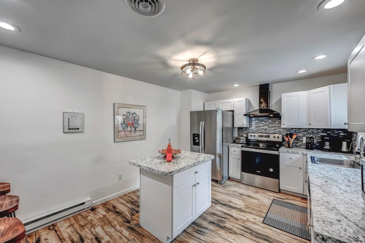 134 Altemose Road Pocono Lake, PA 18347 - Photo 18 of 48 a kitchen with granite countertop a sink cabinets stainless steel appliances and a chandelier