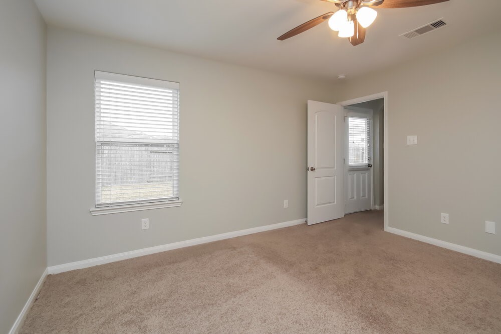 2131 Golden Topaz Drive Rosharon, TX 77583 - Photo 11 of 16 an empty room with chandelier fan and windows