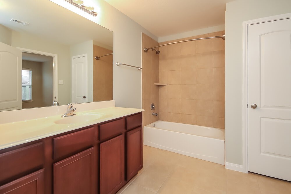 2131 Golden Topaz Drive Rosharon, TX 77583 - Photo 13 of 16 a bathroom with a tub a sink and a mirror
