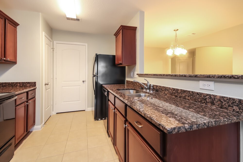 2131 Golden Topaz Drive Rosharon, TX 77583 - Photo 8 of 16 a kitchen with granite countertop a sink and a refrigerator
