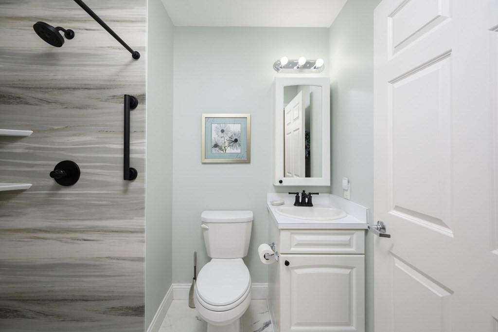 7 Assinippi Avenue, Unit 213 Norwell, MA 02061 - Photo 11 of 26 a bathroom with a sink a toilet and mirror