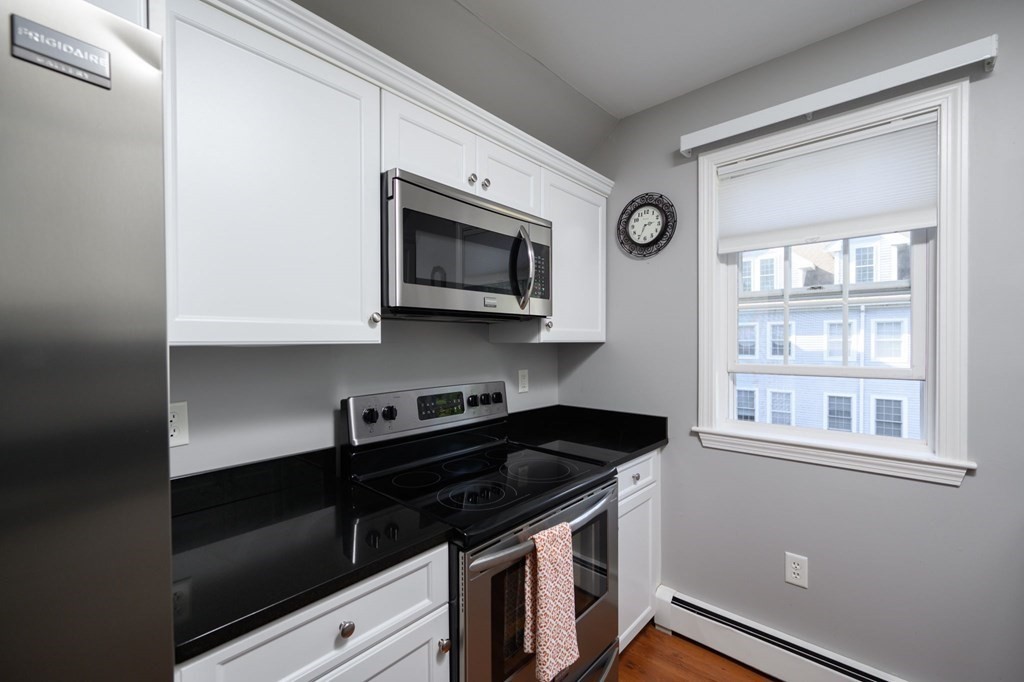 7 Assinippi Avenue, Unit 213 Norwell, MA 02061 - Photo 2 of 26 a kitchen with stainless steel appliances granite countertop a stove microwave and sink