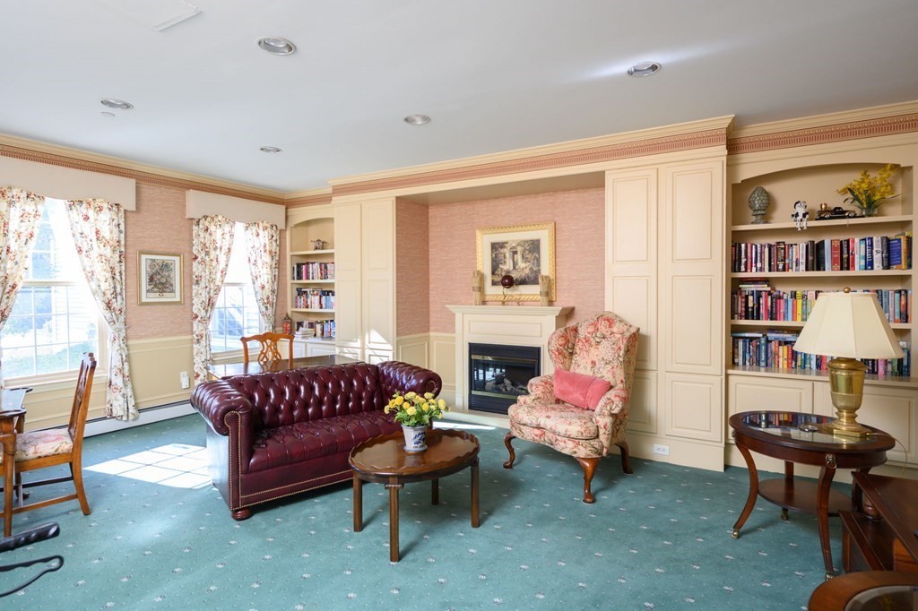 7 Assinippi Avenue, Unit 213 Norwell, MA 02061 - Photo 23 of 26 a living room with furniture a rug and a bookshelf