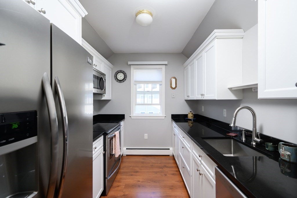 7 Assinippi Avenue, Unit 213 Norwell, MA 02061 - Photo 4 of 26 a kitchen with granite countertop a refrigerator and a sink
