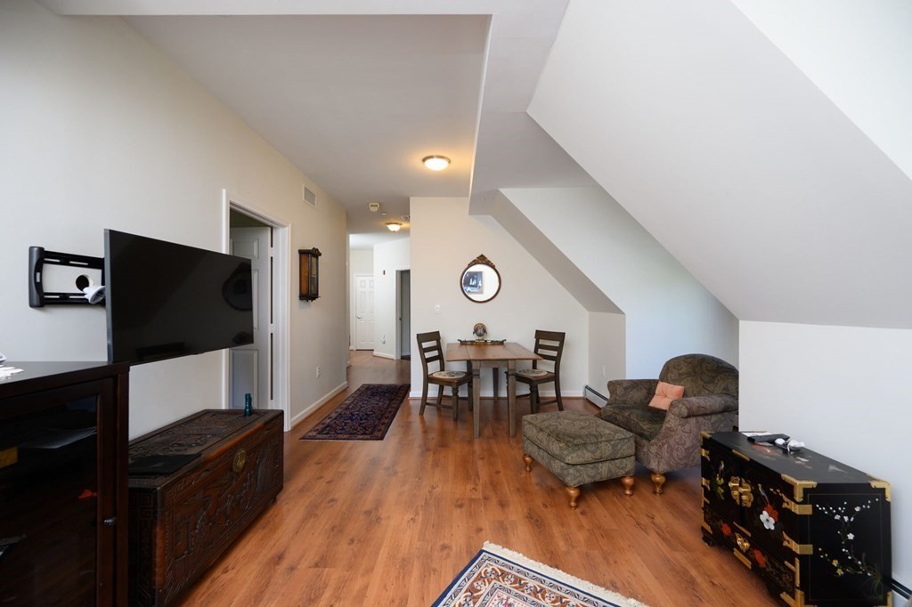 7 Assinippi Avenue, Unit 213 Norwell, MA 02061 - Photo 8 of 26 a living room with furniture and a flat screen tv