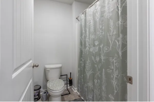 a white toilet sitting next to a shower curtain