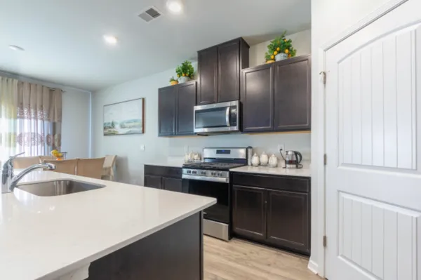 a kitchen with granite countertop a sink stove and refrigerator