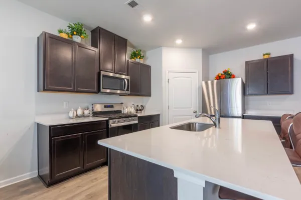 a kitchen with stainless steel appliances granite countertop a sink stove and refrigerator
