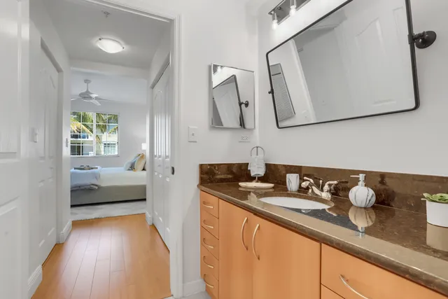 a en suite bathroom with a granite countertop sink and a mirror