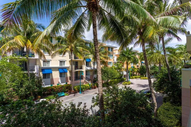 a front view of multi story residential apartment building with yard and green space