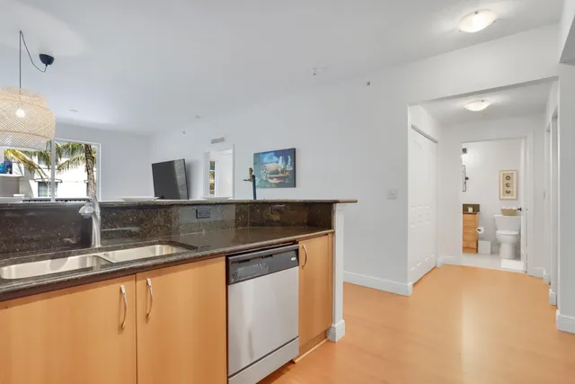 a kitchen with stainless steel appliances granite countertop a sink and a refrigerator