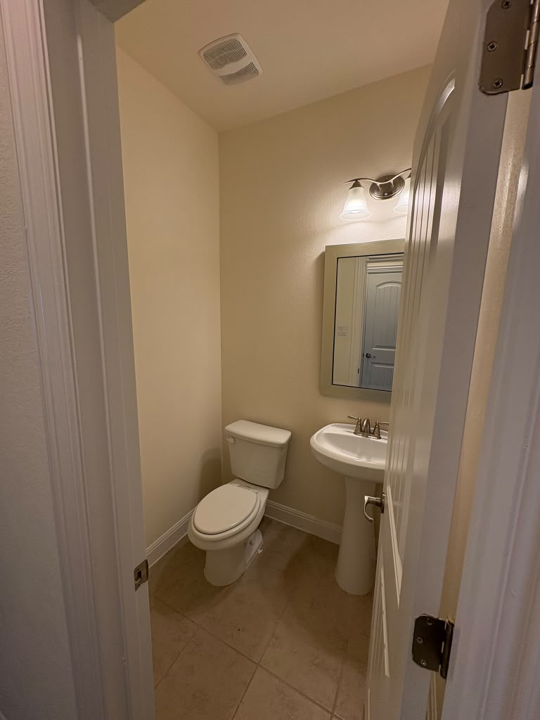 3812 Alpine Rdg Cove Leander, TX 78641 - Photo 33 of 37 A compact powder room with practical tile flooring and pedestal sink.