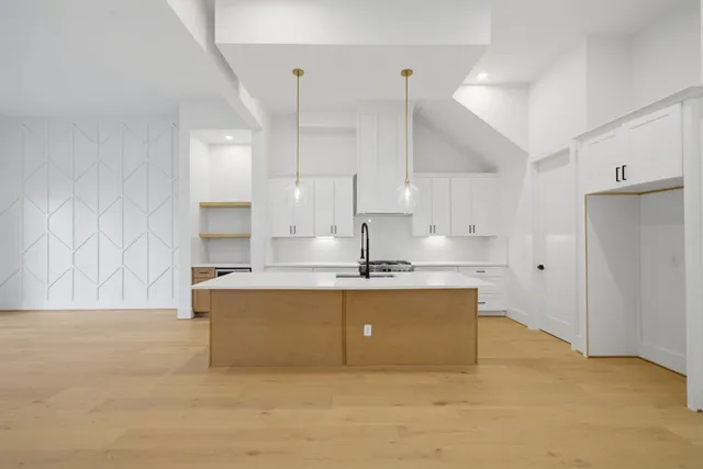 a large kitchen with kitchen island a sink stainless steel appliances and cabinets