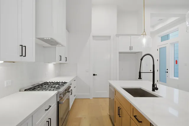 a kitchen with a sink a stove and cabinets