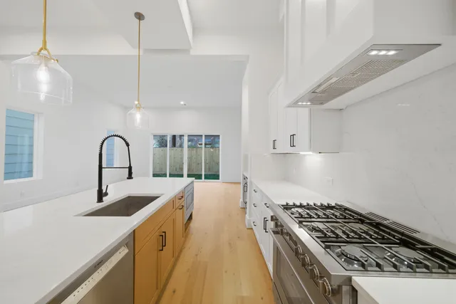 a kitchen with sink a stove and chairs