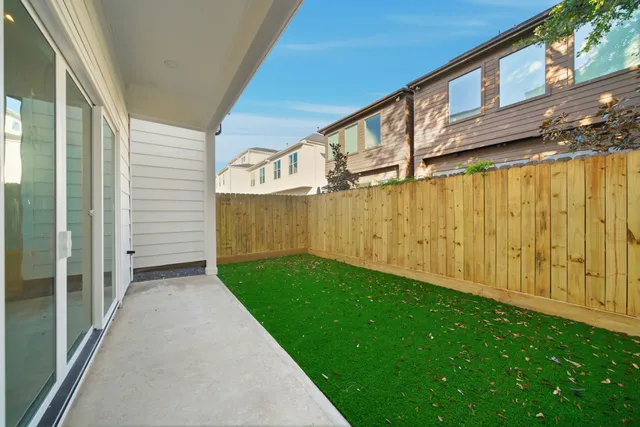 a view of a back yard with wooden fence