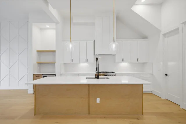 a kitchen with kitchen island granite countertop a sink a center island stainless steel appliances and cabinets