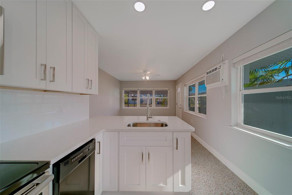 13248 4th Street East, Unit A Madeira Beach, FL 33708 - Photo 11 of 54 a kitchen with granite countertop white cabinets and window