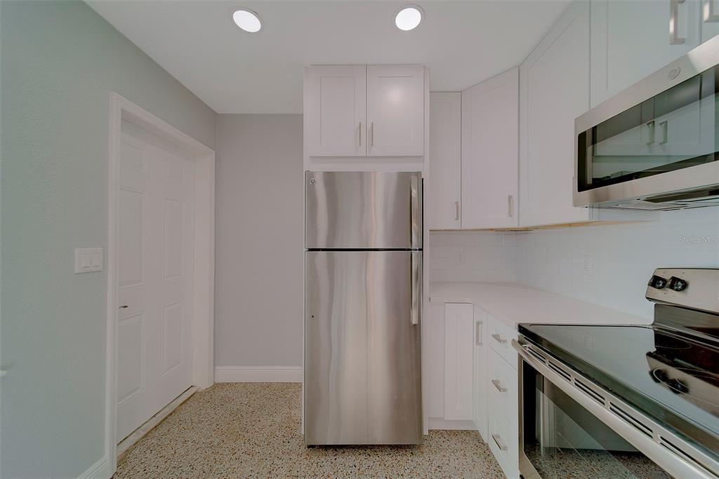 13248 4th Street East, Unit A Madeira Beach, FL 33708 - Photo 12 of 54 a kitchen with stainless steel appliances granite countertop a refrigerator and a stove top oven