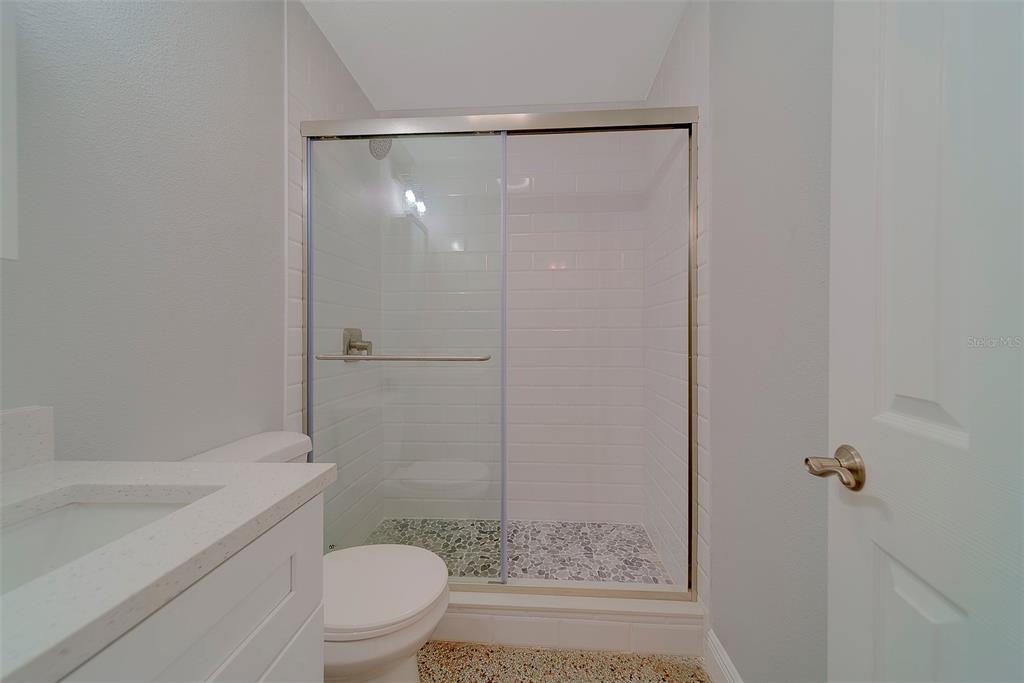 13248 4th Street East, Unit A Madeira Beach, FL 33708 - Photo 17 of 54 a bathroom with a shower a toilet and a sink