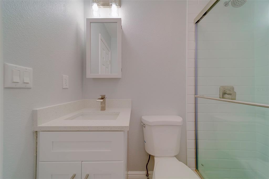 13248 4th Street East, Unit A Madeira Beach, FL 33708 - Photo 18 of 54 a bathroom with a toilet sink and mirror