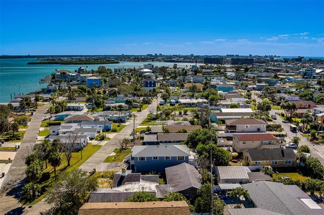 an aerial view of a city with lots of residential buildings ocean and mountain view in back