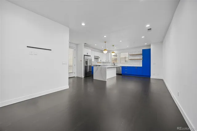 a view of an empty room with wooden floor and windows