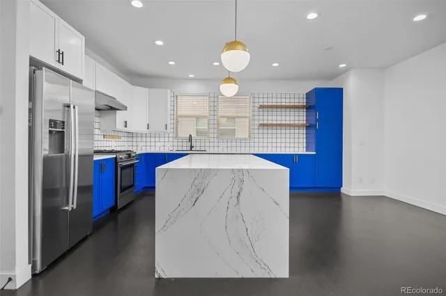 a kitchen with stainless steel appliances granite countertop a sink stove and refrigerator