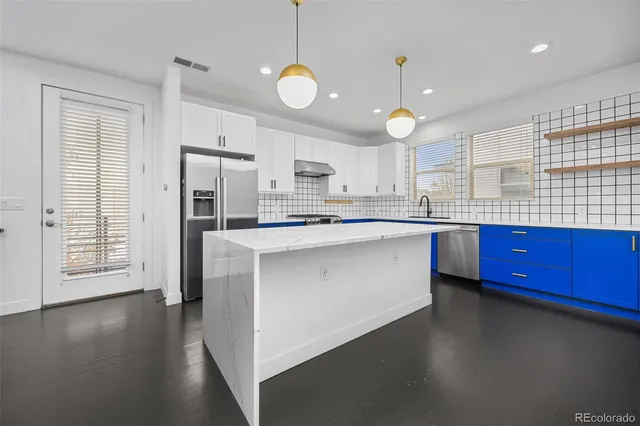 a bedroom with a large bed couch and paintings on the wall