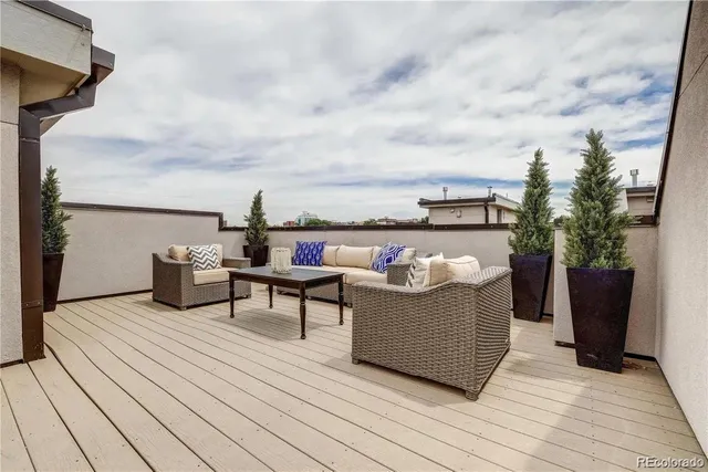 a view of a roof deck with couches and sky view