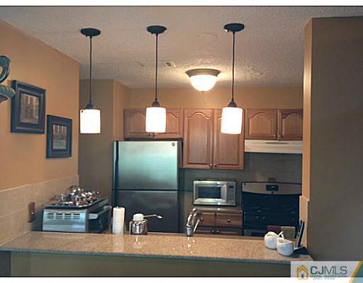 221 Edpas Road New Brunswick, NJ 08901 - Photo 5 of 18 a kitchen with stainless steel appliances granite countertop a refrigerator a stove and a wooden floor