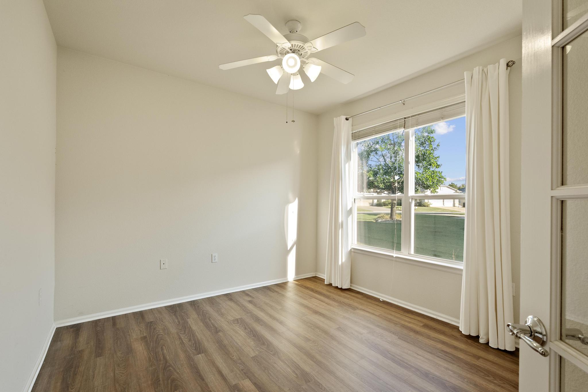 136 Prairie Creek Trail Georgetown, TX 78633 - Photo 11 of 31 an empty room with wooden floor fan and windows