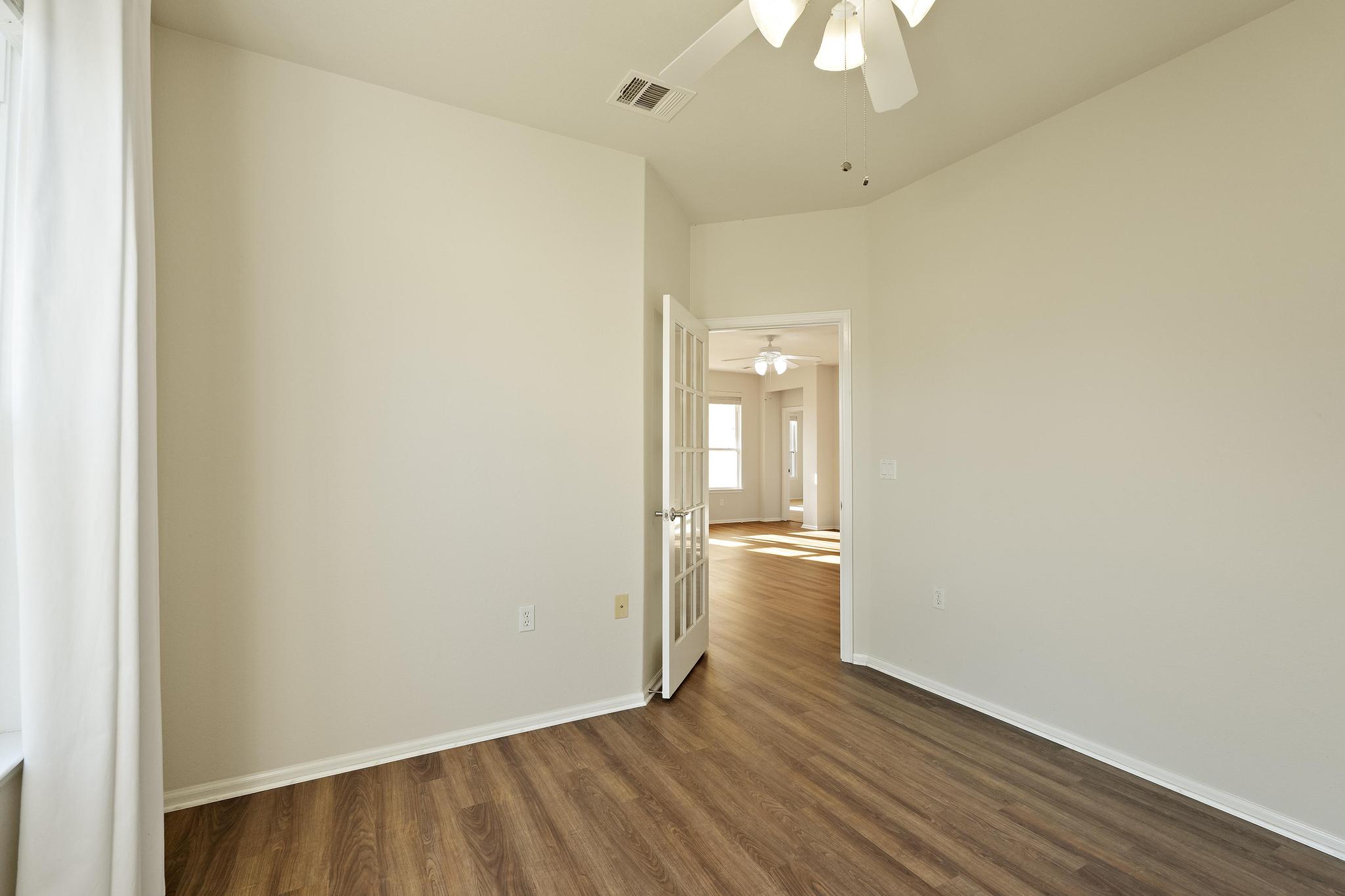136 Prairie Creek Trail Georgetown, TX 78633 - Photo 12 of 31 a view of wooden floor and a chandelier fan in a room