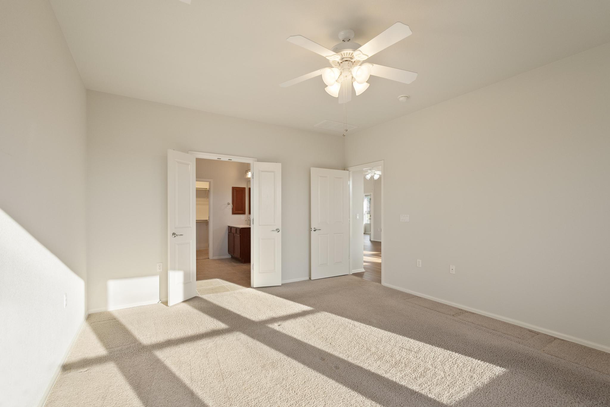 136 Prairie Creek Trail Georgetown, TX 78633 - Photo 17 of 31 Unfurnished bedroom with ensuite bath, carpet floors, and ceiling fan