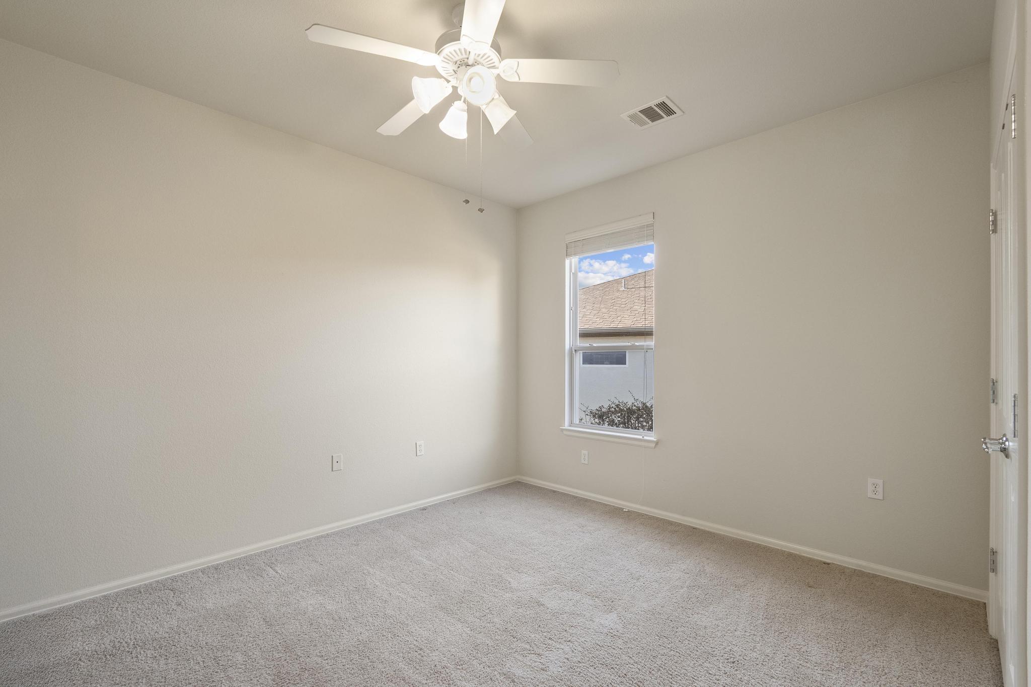 136 Prairie Creek Trail Georgetown, TX 78633 - Photo 22 of 31 an empty room with a chandelier fan and windows