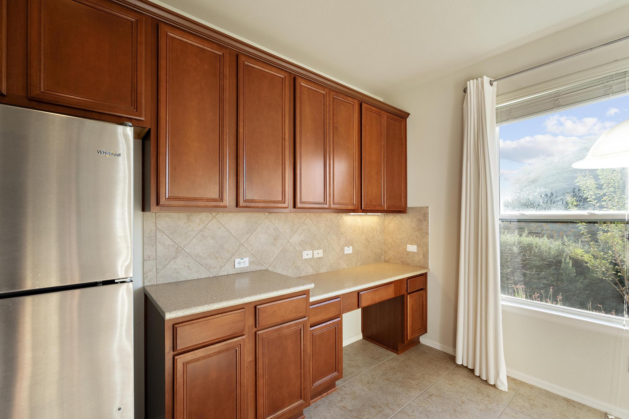 136 Prairie Creek Trail Georgetown, TX 78633 - Photo 8 of 31 a utility room with stainless steel appliances granite countertop a refrigerator and a sink