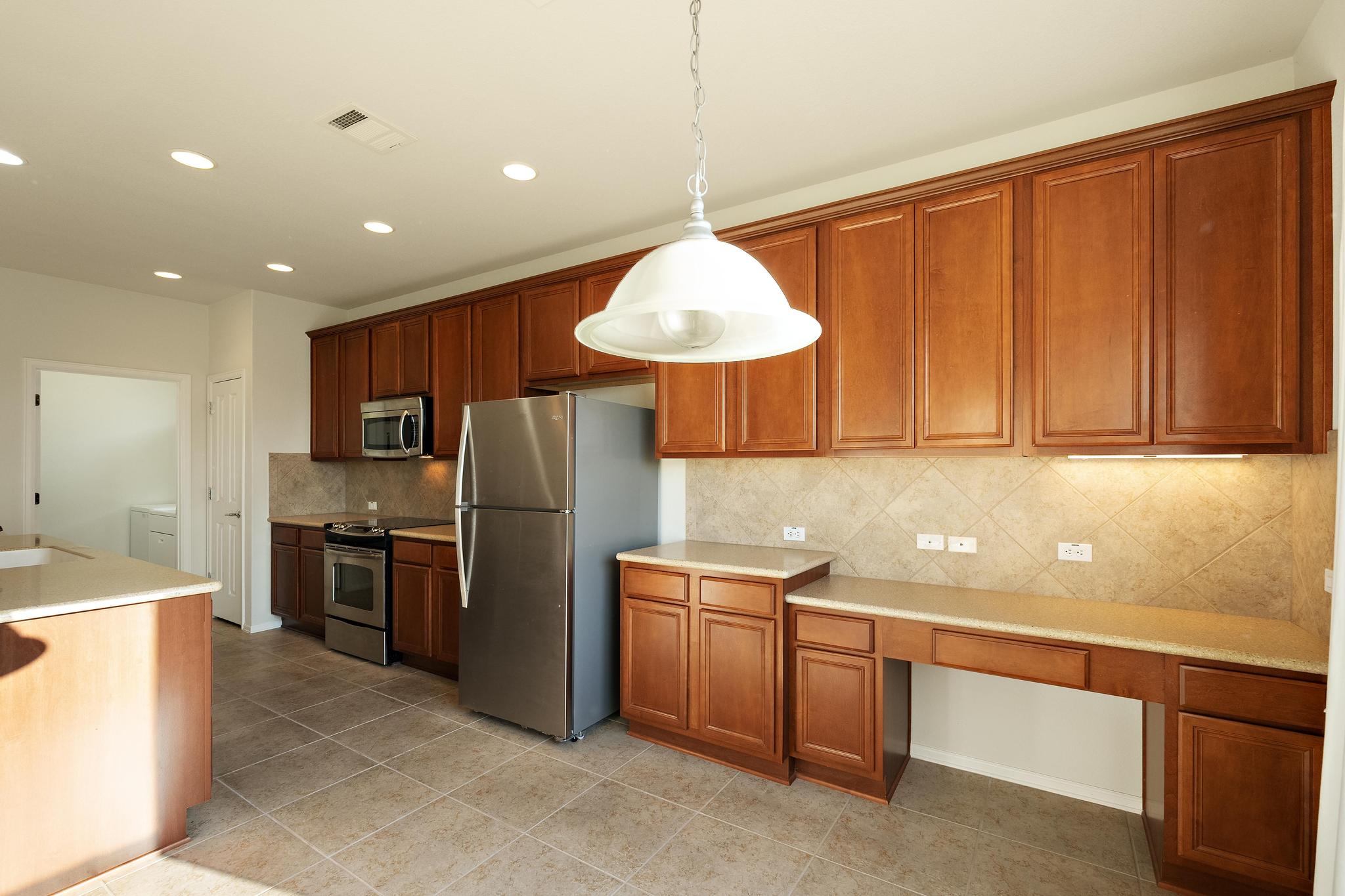 136 Prairie Creek Trail Georgetown, TX 78633 - Photo 10 of 31 a kitchen with a refrigerator sink and cabinets